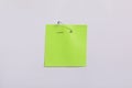 Light green paper note attached with safety pin to white background, top view Royalty Free Stock Photo