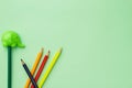 Pencil sharpener in the form of an elephant and five chaotic pencils on a pale green background Royalty Free Stock Photo