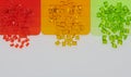 light green, red and orange transparent plastic granulates with samples Royalty Free Stock Photo