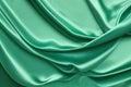Light Green Satin Background. Beautiful pale emerald green luxury satin fabric texture with light wavy folds Royalty Free Stock Photo