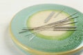 Light green stone coaster with acupuncture needles on white table, closeup Royalty Free Stock Photo