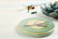 Light green stone coaster with acupuncture needles on white wooden table, closeup. Space for text Royalty Free Stock Photo