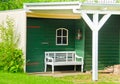 A Light Green And Wooden Small Shed, Gardenhouse, With A Bench Some Tools Around It