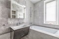 Light grey bathroom with bathtub sink and window