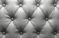Light grey tufted leather surface with round buttons. Diamond quilted pattern creates elegant textural background. Classic Royalty Free Stock Photo