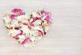 Light heart shape from pink and white rose and orchid petals on wooden background. Love and romance concept Royalty Free Stock Photo