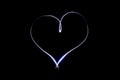 Light heart symbol on isloted black background. Long exposure creative photography. Light painting