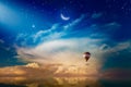 Light from heaven, crescent and hot air balloon rising above serene sea in sunset glowing sky Royalty Free Stock Photo