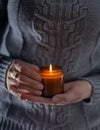 Light and hold a soy candle in your hands. Candle in a jar. Aromatheramia. Aroma candle. Royalty Free Stock Photo