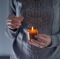 Light and hold a soy candle in your hands. Candle in a jar. Aromatheramia. Aroma candle. Royalty Free Stock Photo