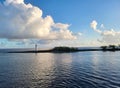 Light house on coastal Island serene tranquil early morning ocean cumulus cloud sky water blue trees plantlife Royalty Free Stock Photo