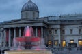 Light illuminates the water in one of the fountains at Trafalgar Square, Westminster, London, UK at dusk.