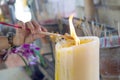 Light incense on a large candle to worship the god of Buddhism