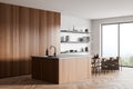 Light kitchen interior with countertop and seats, kitchenware and panoramic window Royalty Free Stock Photo