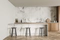 Light kitchen interior with marble table and bar chairs on parquet floor Royalty Free Stock Photo