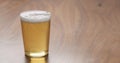 Light lager beer in thin wall glass on wood table with copy space