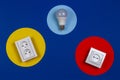 Light lamp bulb and electrical power sockets on geometrical yellow red and navy blue background Royalty Free Stock Photo