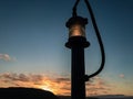 Light from a lamp post from the rear deck of a ship against the sunset in the Bay