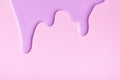 Light lilac liquid drops of paint color flow down on pink background. Abstract purple backdrop with fluid drip pattern Royalty Free Stock Photo