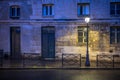 The light of lonely street lamp on the evening street of Paris after the rain