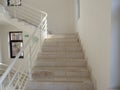 Light marble steps with white railings, white walls and windows with dark frames Royalty Free Stock Photo