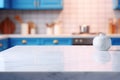 Light marble table with blurred modern blue colored kitchen set, photorealistic blurred bokeh background with copyspace Royalty Free Stock Photo