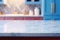 Light marble table with blurred modern blue colored kitchen set, photorealistic blurred bokeh background with copyspace Royalty Free Stock Photo