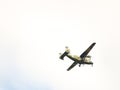 A light military landing turboprop aircraft of the Polish Armed Forces flies across the sky with landing gears released