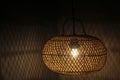 Light of modern hanging wooden lamp, hanging on the ceiling in the bedroom at night. Lamp shade. Light and shadow. Royalty Free Stock Photo