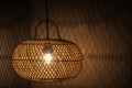 Light of modern hanging wooden lamp, hanging on the ceiling in the bedroom at night. Lamp shade. Light and shadow. Royalty Free Stock Photo