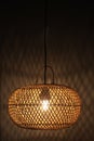 Light of modern hanging wooden lamp, hanging on the ceiling in the bedroom at night. Lamp shade. Light and shadow. Royalty Free Stock Photo