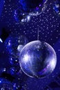Light and music disco ball on a blue background. A rotating disco ball in a nightclub with sparkling effects.