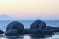 Large boulders at sea with birds and hazy sunrise