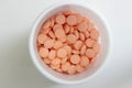 Light orange tablets in white jar in medical healthcare drugstore concept,closed up