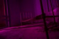 Light painted in pink abandoned bed in dark room. Halloween part Royalty Free Stock Photo