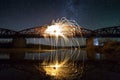 Light painting art concept. Spinning steel wool in abstract circle, firework showers of bright yellow glowing sparkles on long br