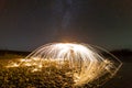 Light painting art concept. Spinning steel wool in abstract circle, firework showers of bright yellow glowing sparkles in fountain
