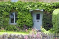 Blue doors in a charming cottage with lush front garden