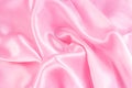 Light pastel pink color silk wavy textile pattern as a smooth textured background. Rose colored soft satin fabric drapery. Royalty Free Stock Photo