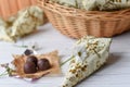 A little present, fresh flowers and some chocolate candies on a white wooden surface