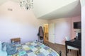 Light pink bedroom with a chandelier, a black desk and mirror, along with a large bed in the middle