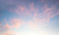 Light pink cirrus clouds at blue sky background, sunset scenery with white shine Royalty Free Stock Photo