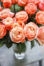 Light pink nd peach bush roses flowers in vase on wooden table. Beautiful summer bouquet. Arrangement with mix flowers