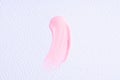 Light pink paint swatch on white paper background. Pink swatch of lip gloss, cosmetic product stroke gouache, oil paint texture,