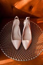 Light pink wedding shoes against the background of an orange chair