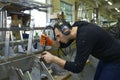 Light planes assembly hall. Worker making holes with a drill on a body plane for further riveting