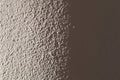 Light plastered wall for background. Light from left side. Close Royalty Free Stock Photo