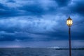 Light Post at nigth near sea with stom background Royalty Free Stock Photo