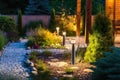 Light posts illuminated backyard garden during night hours. Modern backyard outdoor lighting systems Royalty Free Stock Photo