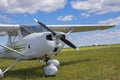 Light private plane parked on the grassy airfield Royalty Free Stock Photo